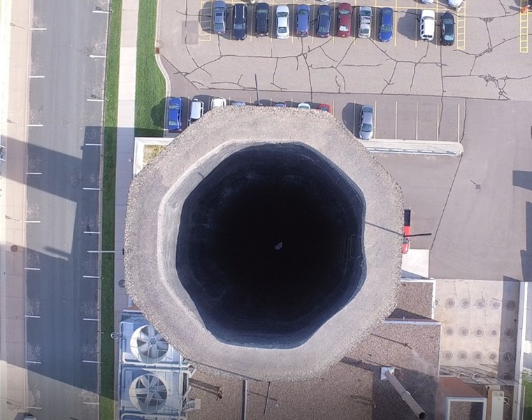 A photograph taken with a drone looking directly down into the main chimney of the central heating plant.